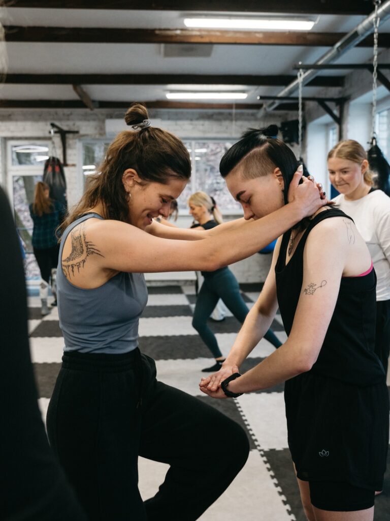 Moterų savigynos dirbtuvės Kaune. Dalyvės mokosi gynybos technikos dirbdamos poromis profesionalioje salėje su treniruočių kilimėliais ir bokso maišais. Lygiosios savigynos dirbtuvės siūlo savigynos pamokas moterims, kuriose išmoksite apsiginti realiose situacijose.