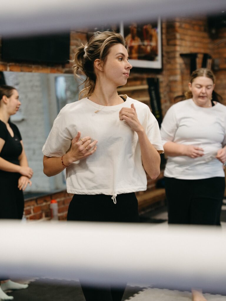 Moterys praktikuoja savigynos technikas poromis kovos menų salėje – Lygiosios savigynos dirbtuvės Kaunas